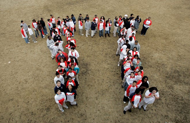 FILE - In this March 13, 2007 file photo, students from the Maurice J. Tobin School makes a human pi symbol at the school in Boston during a celebration of Pi Day. Saturday is the day when love of math and a hankering for pastry come full circle.