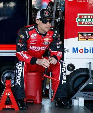 Driver Kevin Harvick watches in the garage before practice for Sunday's NASCAR Sprint Cup Series auto race on Saturday, March 14, 2015, in Avondale, Ariz. (AP Photo/Rick Scuteri)