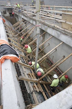 Workers pour concrete at the Canton Water Reclamation Facility, where construction is underway.