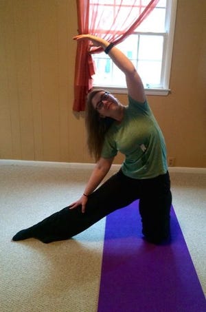 Evangelin Browne, a yoga instructor at Breathing Space on Raeford Road, has molded me into the gate pose at my first yoga class on Saturday, March 14, 2015.