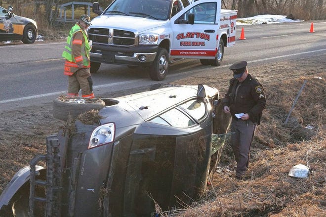 Lenawee County sheriff's Cpl. Conway Linger inspects the scene of a one-car rollover Sunday on M-34 in Dover Township.