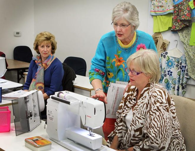 (John Clark/The Gazette) Sew Much Fun! owner Drusilla Munnell, center, teaches a new machine class to Coleen Sigman, left, and Terry Shoecraft, right, at their 831 S. Church St. location in Lowell Monday afternoon. Sew Much Fun will celebrate its 10th anniversary next month.