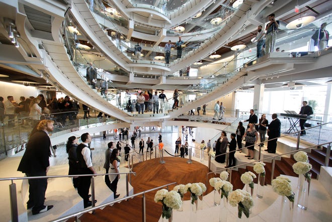Visitors gather in November to listen to singers in the main lobby at the Dr. Phillips Center for the Performing Arts, in Orlando, Fla. The Dr. Phillips Center, financed partially with taxes on tourists, gives the city a world-class venue for many of its performing arts groups and national touring acts. THE ASSOCIATED PRESS