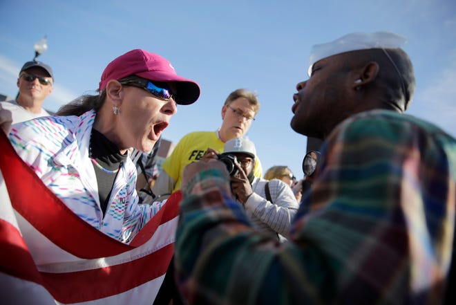 A pro-police protester, left, and counter protester yell at each other outside the Ferguson Police Department on Sunday in Missouri. About 100 people came out to the police station Sunday to show their support for law enforcement.