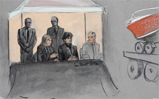 In this courtroom sketch, Dzhokhar Tsarnaev, center seated, is depicted between defense attorneys while the boat in which he was captured in sits on a trailer for observation during his federal death penalty trial, Monday, March 16, 2015, in Boston. Tsarnaev is charged with conspiring with his brother to place two bombs near the Boston Marathon finish line in April 2013, killing three and injuring more than 260 people. (AP Photo/Jane Flavell Collins)