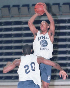 2/12/01 -- Bob Mack/staff -- UNF Ospreys Guard #33 Koran Godwin goes over the top of teammate #20 Chris Ireland during a one-on-one drill in the morning practice session. Godwin is a team leader and scoring leader in their division.