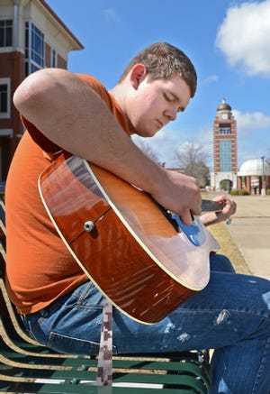 BRIAN D. SANDERFORD • TIMES RECORD / University of Arkansas at Fort Smith student Corey Sanders enjoys the spring-like weather as he waits for friends on Monday, March 16, 2015. Temperatures are forecast to be in the 70s again today with a chance of rain tonight.