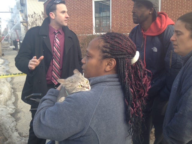 Ayana Carter, 41, holds her cat, Fancy, pulled from a fire in a three-story building on Central Street in Central Falls.