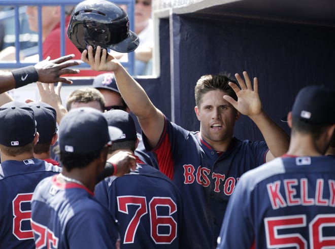 Teammates greet Boston Red Sox Garin Cecchini after he scores a run on March 11. Cecchini has redisovered his timing at the plate after a tough 2014 season. Kathy Willens/THE ASSOCIATED PRESS