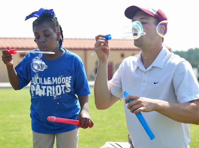 Zykeria Gordon blows bubbles with volunteer Davis Meeks. Hundreds of athletes competed in the Bay Special Olympics on Thursday at Arnold High Schoolin Panama City Beach.