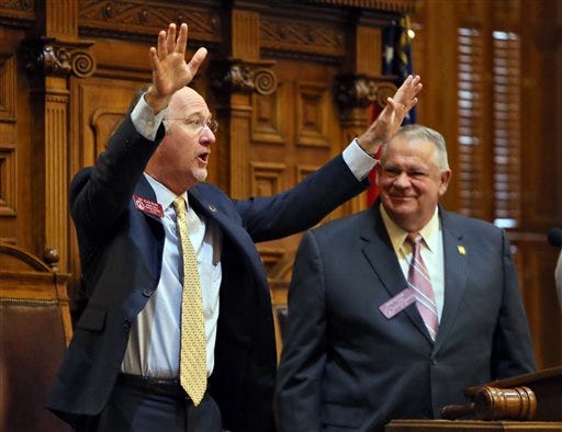 State Rep. Allen Peake, left,, R-Macon, standing with House Speaker David Ralston, acknowledges a standing ovation after the House overwhelmingly passed House Bill 1, Wednesday, Feb. 25, 2015, in Atlanta, to legalize cannabis oil for the treatment of nine major health problems, including sickle cell disease. The bill passed 158-2 and now goes to the state Senate, where considerable opposition is all but certain. Gov. Nathan Deal, who must sign the measure for it to become law, has said he supports the use of cannabis oil for treatment of seizure disorders. (AP Photo/Atlanta Journal-Constitution, Bob Andres)