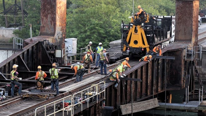Workers swarm the Florida East Coast Railway bridge over the Loxahatchee River on March 23, 2015 as three days of repairs begin. According to information from the Coast Guard, maintenance will be performed on the 90-year-old bridge between 7:30 and 11:30 a.m. and again from 1 to 5 p.m. Monday through Wednesday. The bridge will not be open for boaters during work hours. (Lannis Waters / The Palm Beach Post)