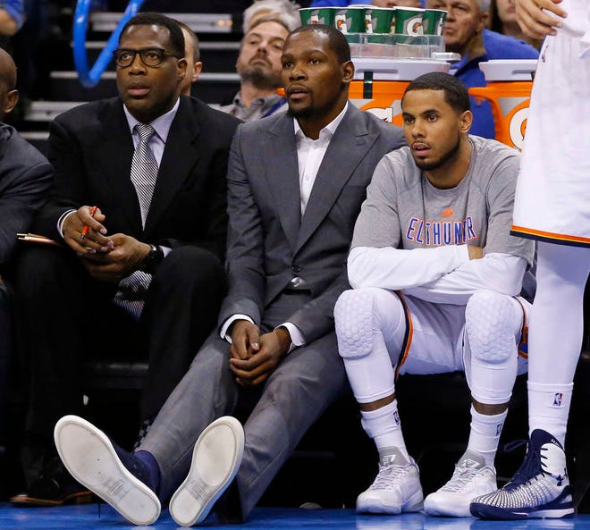 FILE - In this March 4, 2015, file photo, injured Oklahoma City Thunder forward Kevin Durant, center, watches from the bench with guard D.J. Augustin, right, and assistant coach Mark Bryant, left, during the first quarter of an NBA basketball game against the Philadelphia 76ers in Oklahoma City. Reigning NBA MVP Kevin Durant likely won't return this season.General manager Sam Presti said Friday, March 20, 2015, that Durant still has pain in his right foot, well after he was expected to be ready to return. When asked if the best thing would be best to shut him down for the season, Presti said: "Essentially, that's the direction that we're taking right now, in terms of removing him from all basketball-related activities." (AP Photo/Sue Ogrocki, File)