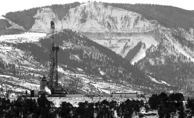 In this photograph taken February 2013, near Parachute, Colo., the drill rig at a natural gas site stands with mountains in the background on Colorado's Western Slope. A campaign to get universities to stop investing in greenhouse gas-producing fuels has come deep into energy country as activists will ask the University of Colorado to divest from coal and peteroleum companies. (AP Photo/David Zalubowski)