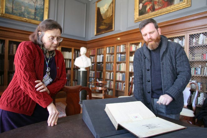 Librarians Holly Snyder and Christopher Geissler show a first-edition folio of Shakespeare's plays, which is part of the collection in the Hay Library's Bruhn Room.