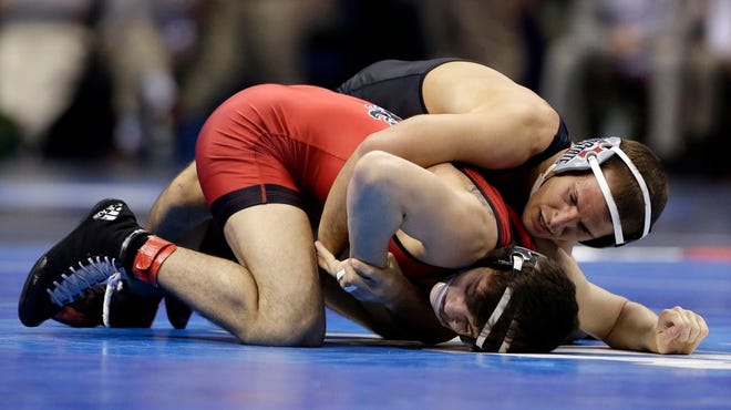 Ohio State’s Logan Stieber (top) wrestles North Carolina State's Kevin Jack during their 141-pound semifinal match Friday at the NCAA Division I Wrestling Championships in St. Louis. Stieber went on to win his fourth straight title.
