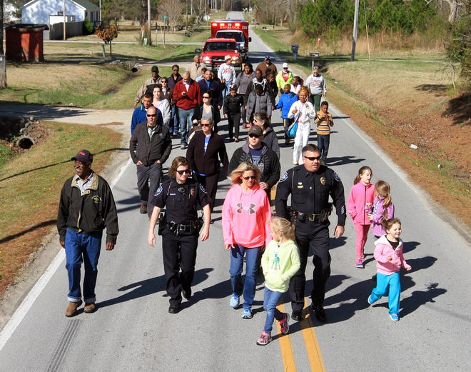 Walkers participate in the East Craven Community March on Saturday in the North Harlowe Community. About three dozen people participated in the event designed to celebrate God and the community.