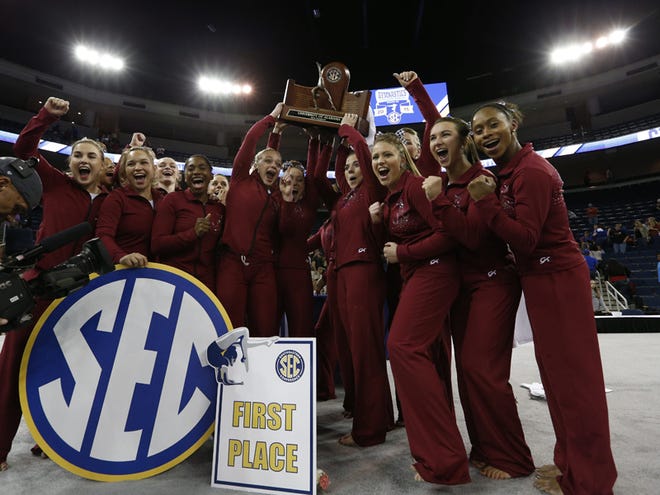 Members of the Alabama gymnastics team celebrate Saturday after winning the SEC Championship in Duluth, Ga. It's the Tide's second straight SEC title.