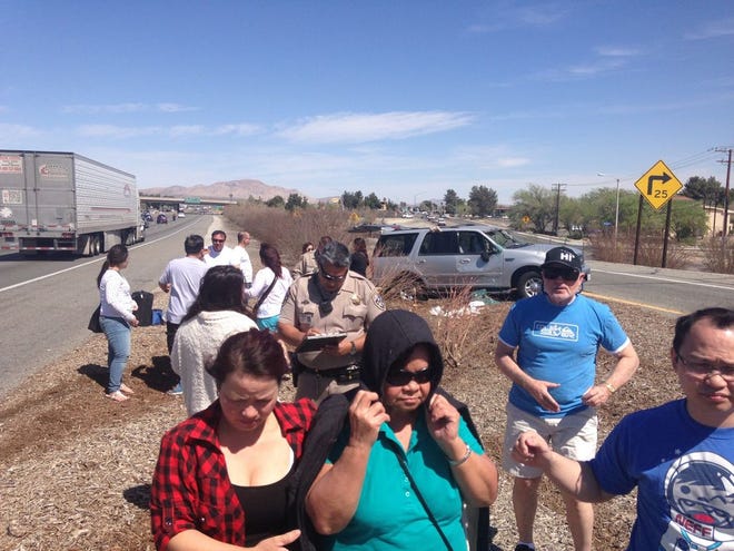 Passengers from a collision on Interstate 15 are escorted away by friends and family. (Brooke Self, Daily Press)