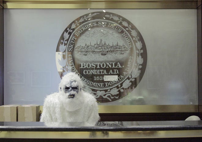 In this March 6, 2015 photo, an anonymous creature known as The Boston Yeti poses in front of the Boston logo at City Hall in Boston. AP Photo/Eric Gulliver