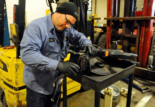 Road service technician Lenny Derusha repairs the handle assembly for a rider pallet jack at Northland Industrial Truck Co. Inc. in Shrewsbury.