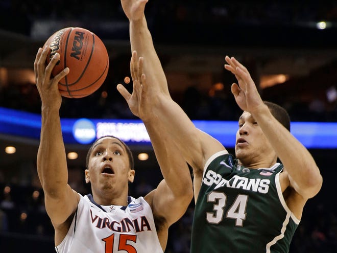 Virginia's Malcolm Brogdon (15) drives past Michigan State's Gavin Schilling (34) during the second half of an NCAA tournament college basketball game in the Round of 32 in Charlotte, N.C., Sunday, March 22, 2015. (AP Photo/Gerald Herbert)