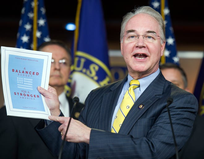 In this March 17, 2015, photo, House Budget Committee Chairman Rep. Tom Price, R-Ga. holds-up a synopsis of the House Republican budget proposal as he announces the plan on Capitol Hill in Washington. The new House and Senate Republican boast that they both balance the federal budget within 10 years, without raising taxes. Their own numbers, however, say millions of American families and businesses would have to pay more in taxes to make the math work. To the tune of about $900 billion more over the next decade. (AP Photo/Cliff Owen)