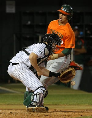 Patrick Mazeika hauls in a throw as Miami’s Willie Abreu scores during a game last season. Mazeika, who is hitting .291 with a team-high five home runs, and the Hatters host Florida at 6:30 p.m.