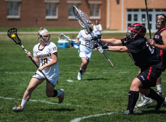 04.12.2014 MOOGLAX Moorestown, NJ - Vero Beach, Florida at Moorestown HS Girls LAX. Moorestown player (18) Abbey Brooks looks for a teamate to pass to. Vero Beach goalie (27) Allison McDonough attempts to block. Laurence Kelly/Freelance