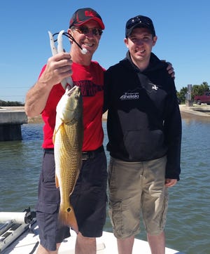 Fred and Kevin Kobza were happy about catching this 26-inch redfish while fishing in Flagler County last week.