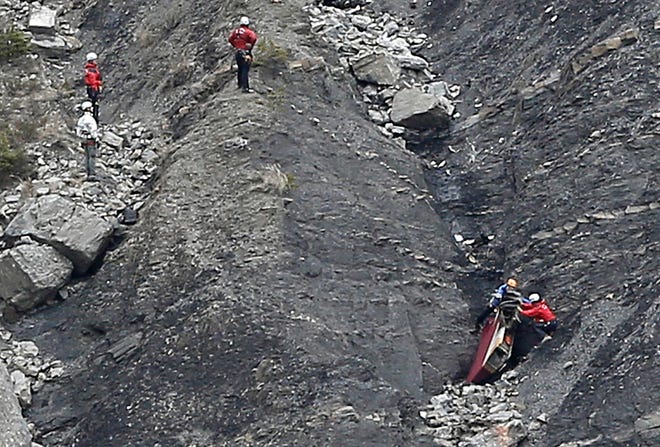 ALTERNATE CROP TO CIP111 - Rescue workers work on debris at the plane crash site near Seyne-les-Alpes, France, Wednesday, March 25, 2015, after a Germanwings jetliner crashed Tuesday in the French Alps. French investigators cracked open the badly damaged black box of a German jetliner on Wednesday and sealed off the rugged Alpine crash site where 150 people died when their plane on a flight from Barcelona, Spain to Duesseldorf, Germany, slammed into a mountain. (AP Photo/Laurent Cipriani)