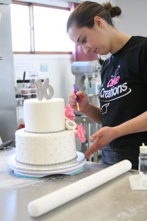 Annie Drummond puts the finishing touches on a cake Thursday, March 12, 2015, at Cake Creations, 3925 N. Alpine Road, Rockford.