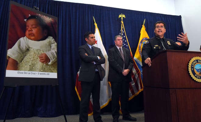 Long Beach Police Chief Robert Luna, right, speaks during a news conference in Long Beach, Calif., Wednesday, March 25, 2015. Southern California authorities have arrested four people in a plot to kidnap two newborn babies. The plot ended with the death of a 3-week-old girl and the shooting and beating of the children's mothers, police said Wednesday. At left is an image of baby Eliza Delacruz, who was snatched Jan. 3, 2015, in Long Beach by a gunman who wounded her parents and uncle, Luna said. Her body was found the next day in a trash bin near the Mexican border. (AP Photo/The Daily Breeze, Scott Varley) MAGS OUT; NO SALES