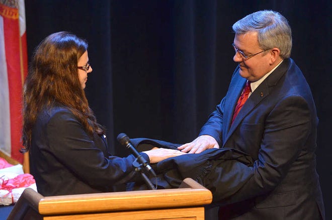 PETER.WILLOTT@STAUGUSTINE.COM St. Johns County Bar Association president Alyssa Camper presents Howard McGillin a judicial robe during an investiture ceremony, held on the campus of Flagler College in St. Augustine, officially making him the county's newest circuit judge on Friday, March 27, 2015.