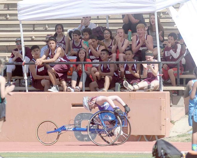 Members of the Hereford track team cheer on River Road's Emily Hilbish as she passes them while competing in the 400 meter wheelchair division Saturday during the 65th annual Amarillo Relays at Dick Bivins Stadium.
