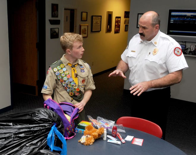 Sam Studer, 17, left, talks to Columbia Fire Chief Randy White about his Eagle Scout project. Sam filled 50 backpacks for young victims of house fires. The backpacks contain toothbrushes, blankets, a toy and other items that children may need following a house fire.