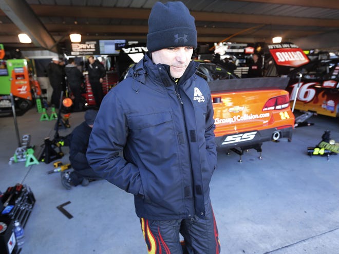 Driver Jeff Gordon is bundled up for the cold as he leaves the garage after practice for Sunday's NASCAR Sprint Cup race at the Martinsville (Virginia) Speedway on Saturday.