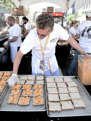 Bruce.Lipsky@jacksonville.com Brad Hoke hustles to stay up with the demand for spicy pimento grilled cheese sandwiches at the Bistro Aix tent in the One Spark Food Village during last year's festival.