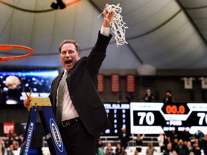 Michigan State coach Tom Izzo holds up the net after his team defeated Louisville 76-70 in overtime in the NCAA men's college basketball tournament East Regional in Syracuse, N.Y., Sunday, March 29, 2015.