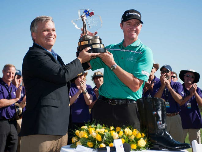 Valero Texas Open winner Jimmy Walker, right, holds the tournament trophy with Valero executive vice president Lane Riggs after the fourth round of the Valero Texas Open golf tournament, Sunday, March 29, 2015, in San Antonio. (AP Photo/Darren Abate)