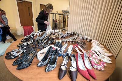 Photos by Warren Westura / New Jersey Herald - Eileen Cahill of Green sorts through some of the free shoes which are part of the deal with free prom dresses at Project Self Sufficiency in Newton.