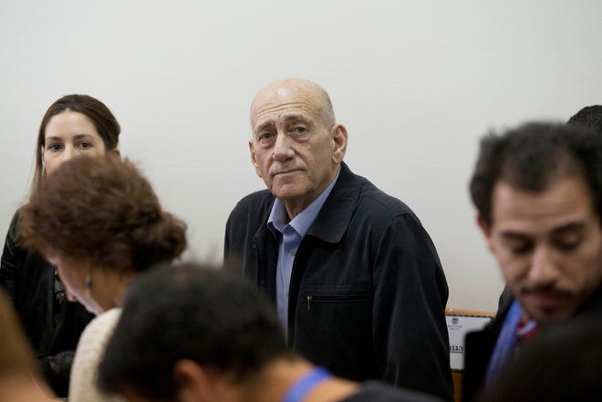 Former Israeli Prime Minister Ehud Olmert, center, waits for a verdict in Jerusalem's District Court on Monday. THE ASSOCIATED PRESS