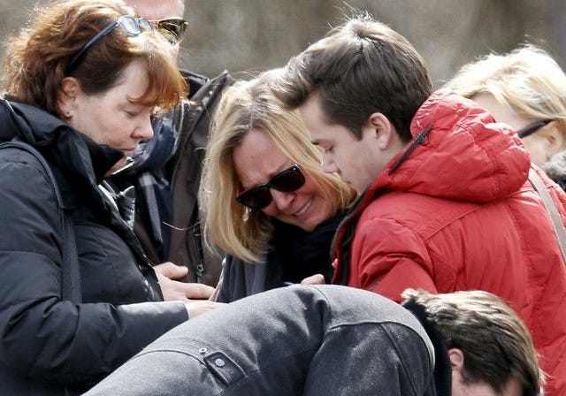 People identified by the mayor of Le Vernet as family members of the pilot of the Germanwings Airbus A320 react as they pay their respects at the memorial for the victims of the air disaster in the village of Le Vernet, near the crash site of the Germanwings Airbus A320 in French Alps March 28, 2015. The co-pilot suspected of deliberately crashing a passenger plane in the French Alps told his girlfriend he was in psychiatric treatment, and that he was planning a spectacular gesture that everyone would remember, the German daily Bild reported on Saturday. REUTERS/Jean-Paul Pelissier    
 Flags representing some of the nationalities of the victims are seen as family members and relatives gather at the momorial, near the crash site of a Germanwings Airbus A320, in Le Vernet, in French Alps, March 29, 2015. The co-pilot suspected of deliberately crashing a passenger plane in the French Alps told his girlfriend he was in psychiatric treatment, and that he was planning a spectacular gesture that everyone would remember, the German daily Bild reported on Saturday.    REUTERS/Jean-Paul Pelissier