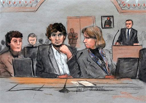 In this March 5, 2015 file courtroom sketch, Dzhokhar Tsarnaev, center, is depicted between defense attorneys Miriam Conrad, left, and Judy Clarke, right, during his federal death penalty trial in Boston. Prosecutors rested their case against Tsarnaev on Monday, March 30, 2015, after jurors saw gruesome autopsy photos and heard a medical examiner describe the devastating injuries suffered by the three people who died in the 2013 terror attack. (AP Photo/Jane Flavell Collins, File)
