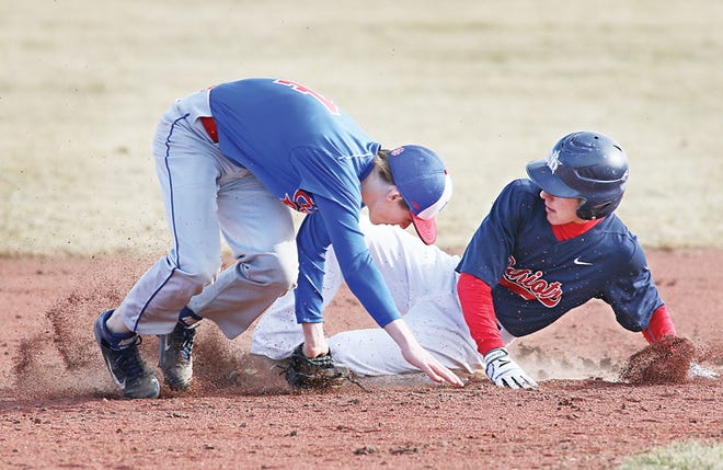 Britton Deerfield’s Christopher Steiler slides into second base and is safe as Lenawee Christin shortstop Alex Eberly, left, can’t field the throw cleanly during Monday’s season-opening game. Britton Deerfield won both games, 16-4 and 8-7.