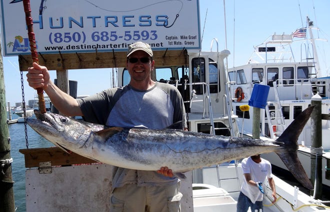 Steve Briley of Chicago shows off his 57-pound king mackerel he caught Monday aboard the Huntress. He caught the mackerel while they were bottom fishing for amberjack using a pogey for bait. “I’d rather be lucky than good,” said first mate Groovy of the catch.