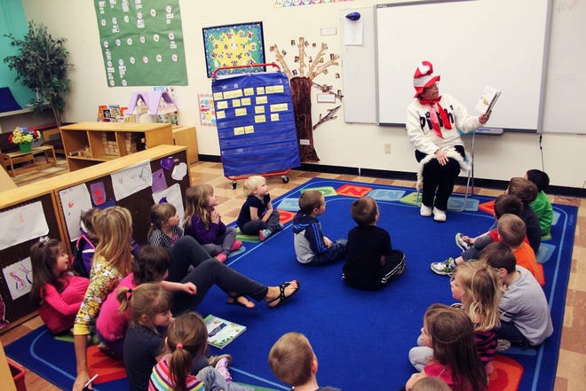 Joyce Patterson, dressed as Dr. Seuss, reads aloud to the Monmouth-Roseville Tiny Titans pre-K class on Monday, during the Warren County Book Drop-off.