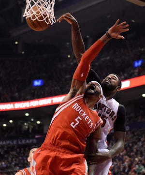 Toronto Raptors' Amir Johnson battles for a rebound with Houston Rockets' Josh Smith during the first half of an NBA basketball game in Toronto, Monday, March 30, 2015. (AP Photo/The Canadian Press, Frank Gunn)