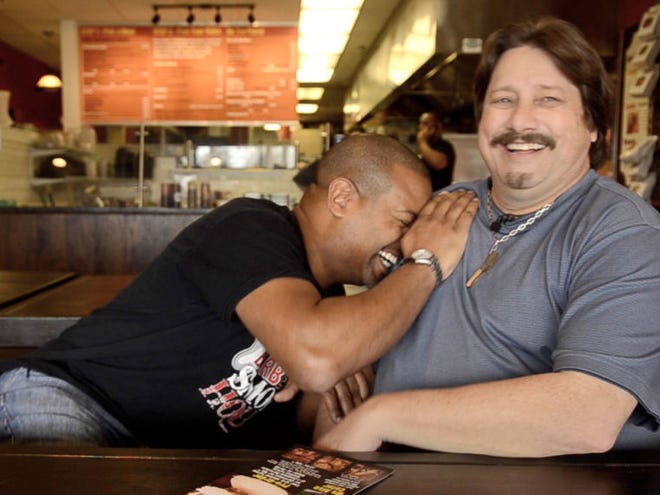 Jim Barbour, owner of FunniBonz Barbecue Smoke House in Robbinsville, NJ, leans on Eat This host Chuck Thomas after missing a line during a shoot last year. staff photo by Bill Fraser