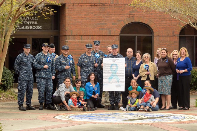 Capt. James Jenks, commanding officer of Naval Submarine Base Kings Bay, displays a signed proclamation at Fleet and Family Support Center declaring April as Child Abuse Prevention Month.